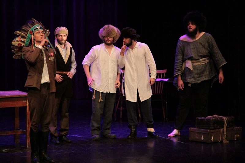 Na scenie pięciu mężczyzn, jeden ma na głowie pióropusz
