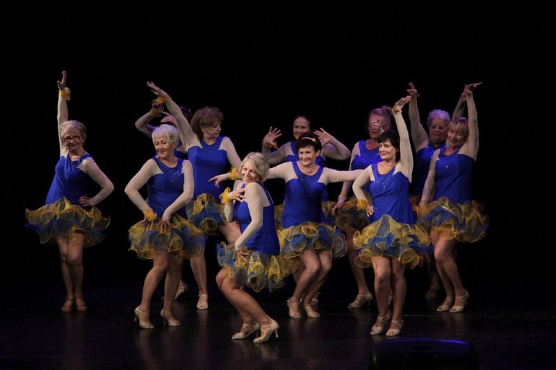 Na scenie tańczą kobiety w niebieskich sukienkach