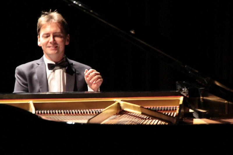Uśmiechnięty mężczyzna gra na fortepianie