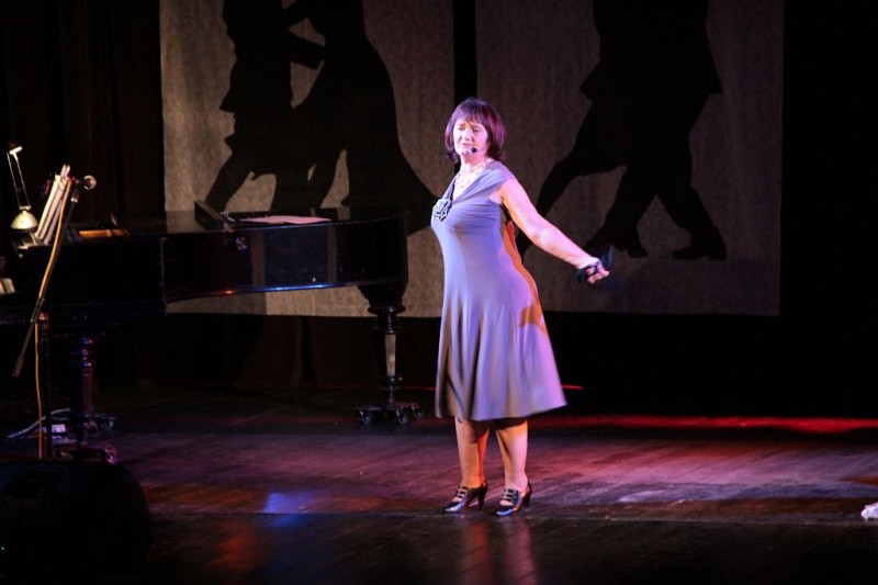 Na scenie kobieta we fioletowej sukience
