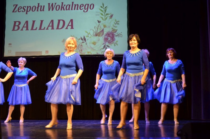 Kobiety w niebieskich sukienkach tańczą na scenie