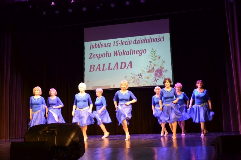 Kobiety  niebieskich sukienkach tańczą na scenie