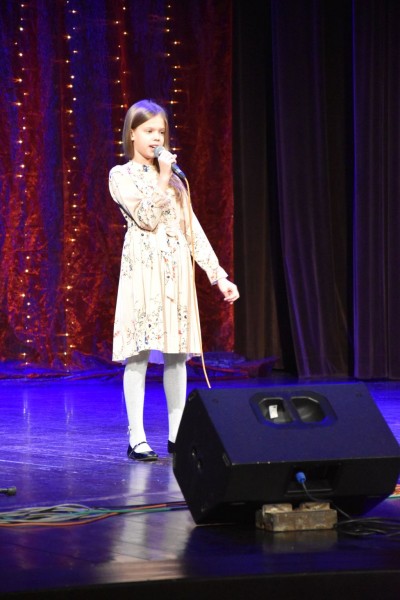 Na scenie dziewczyna w kwiecistej sukience