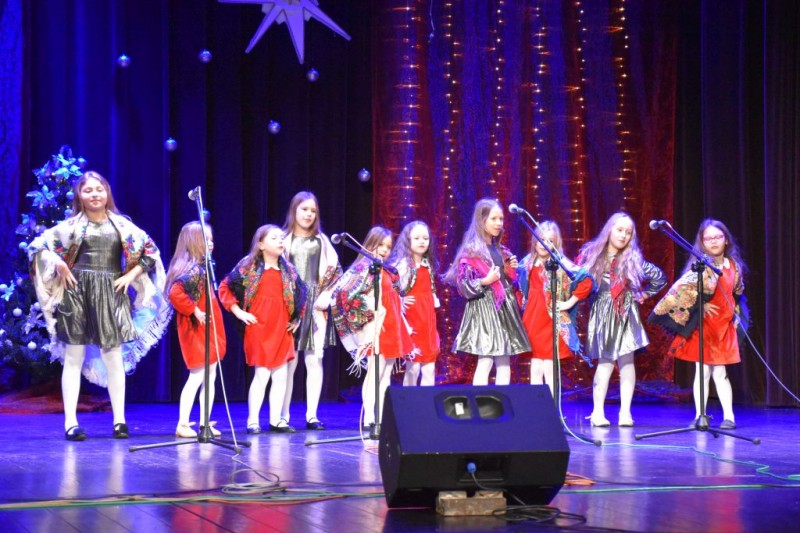 Na scenie zespół dziewczynek w czerwonych sukienkach