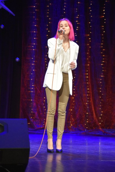 Na scenie dziewczyna z różowymi włosami