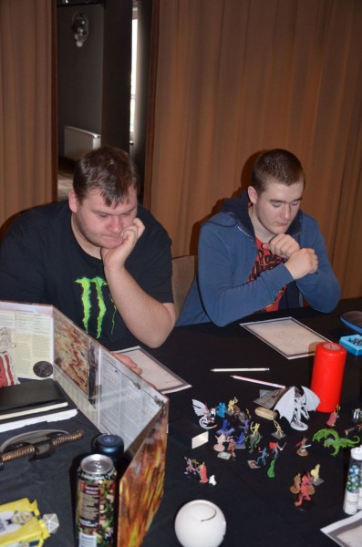 Dwóch mężczyzn przy stole patrzy na plansze do gry