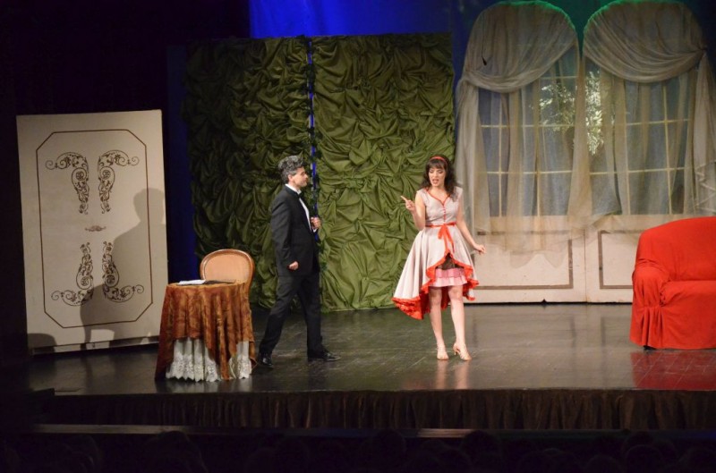 Kobieta i mężczyzna na scenie. Kobiieta ma biało-czerwoną sukienkę
