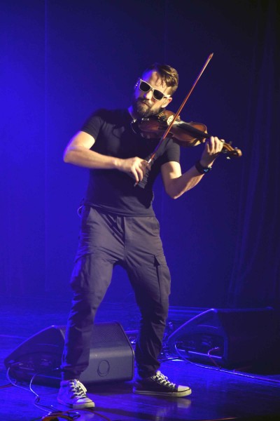 Mężczyzna w ciemnych okularach gra na skrzypach