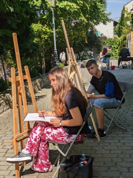 Dziewczyna i chłopak malują obrazy w plenerze