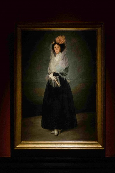 Obraz kobiety w czarnej sukience z dużym kwiatem we włosach