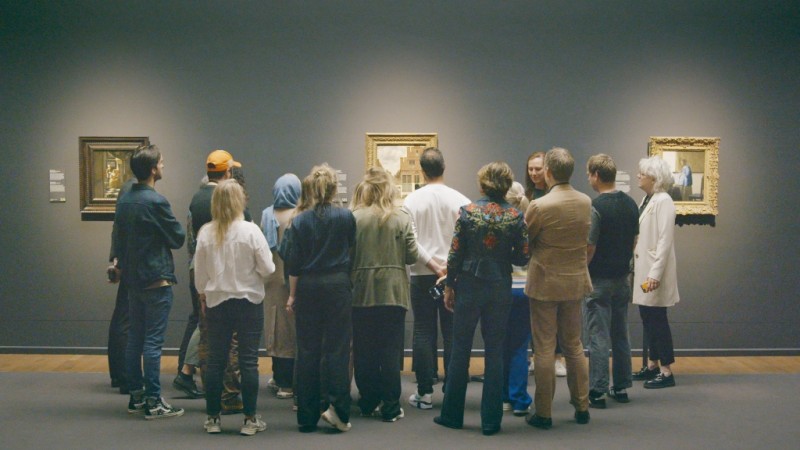 Grupa ludzi patrzy na obraz w galerii