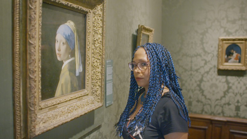Kobieta w niebieskich włosach patrzy na obraz