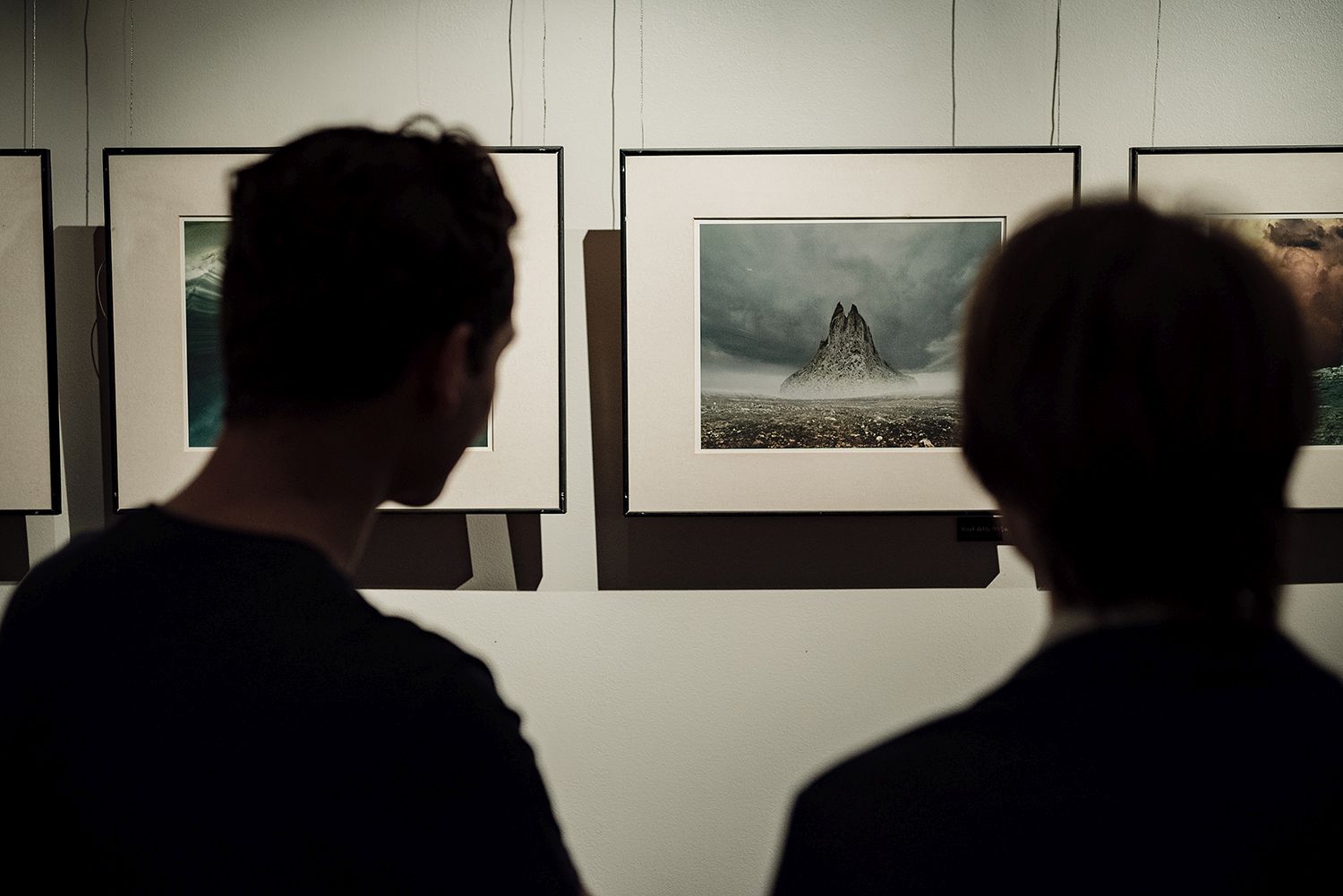 Dwóch widzów podziwiający zdjęcia Zdzisława Beksińskiego na wystawie w OCK